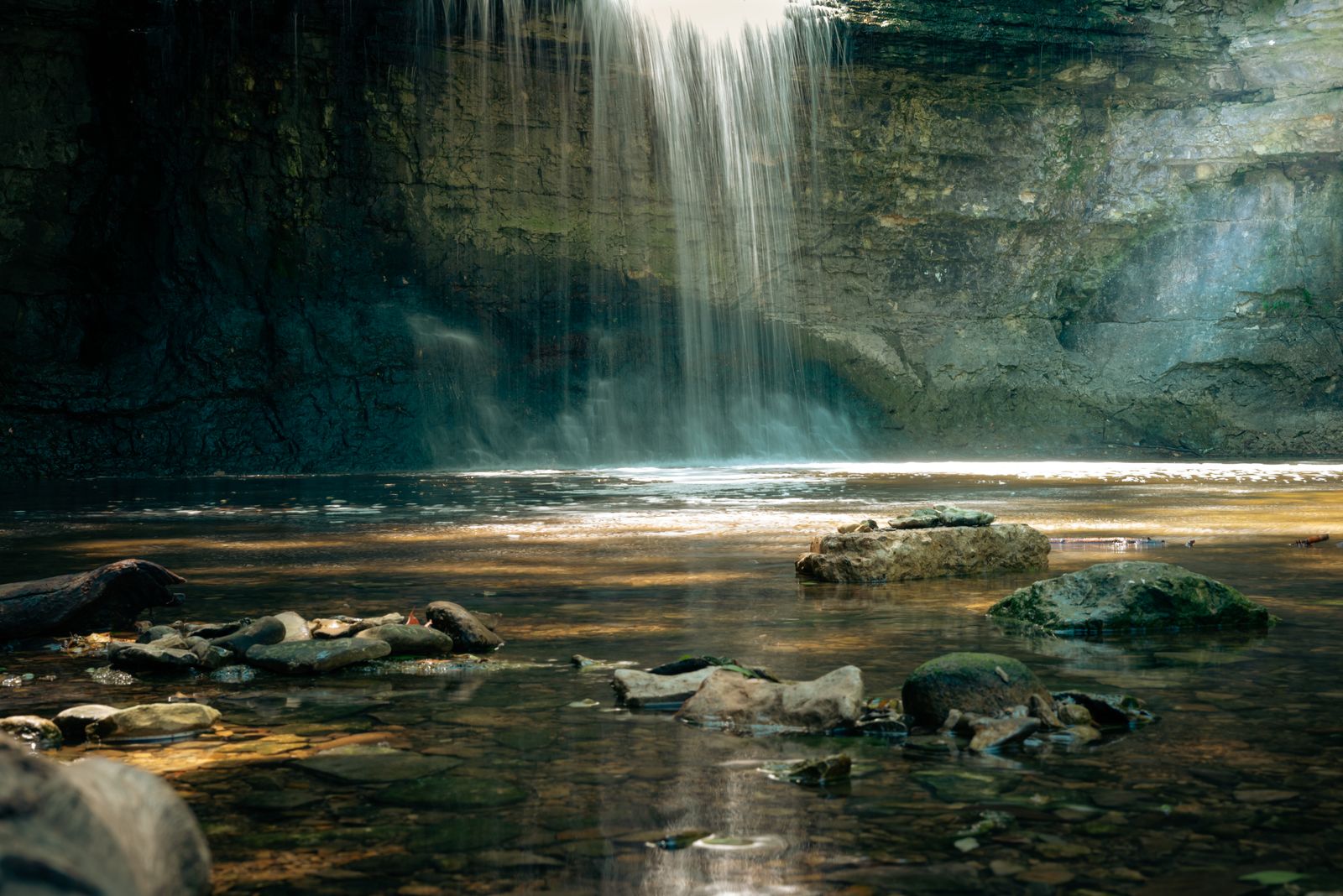 Rocky natural plunge pool beside a waterfall