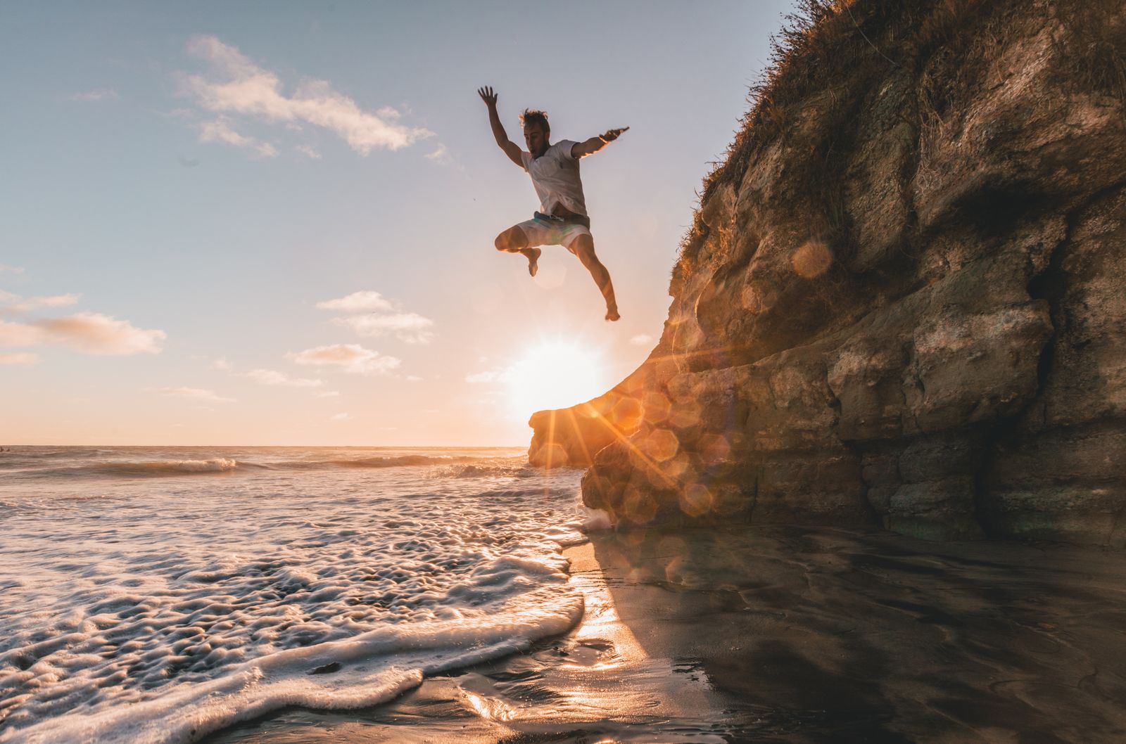 Person cliff jumping into the ocean