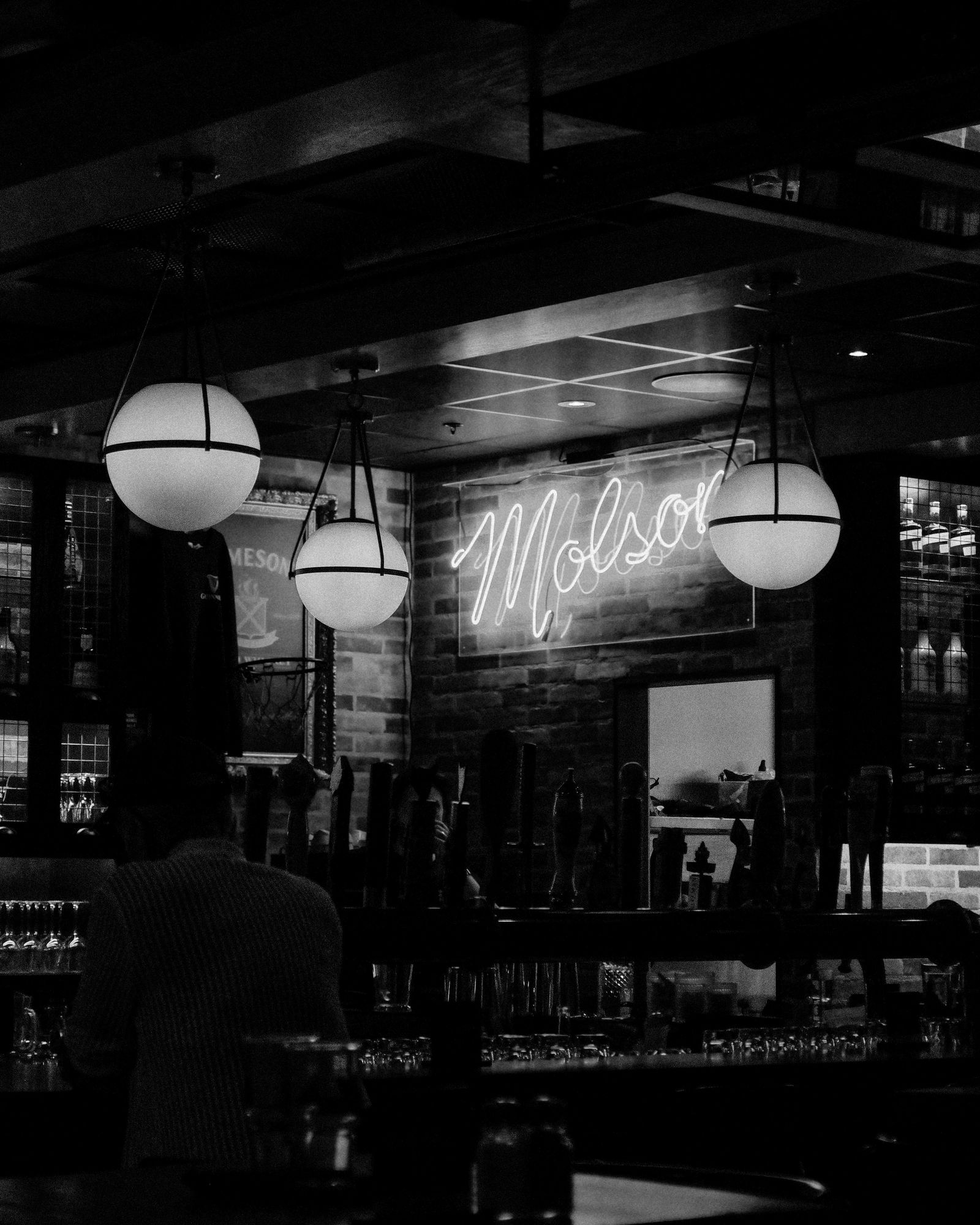 Moody, dimly lit bar interior with neon signage