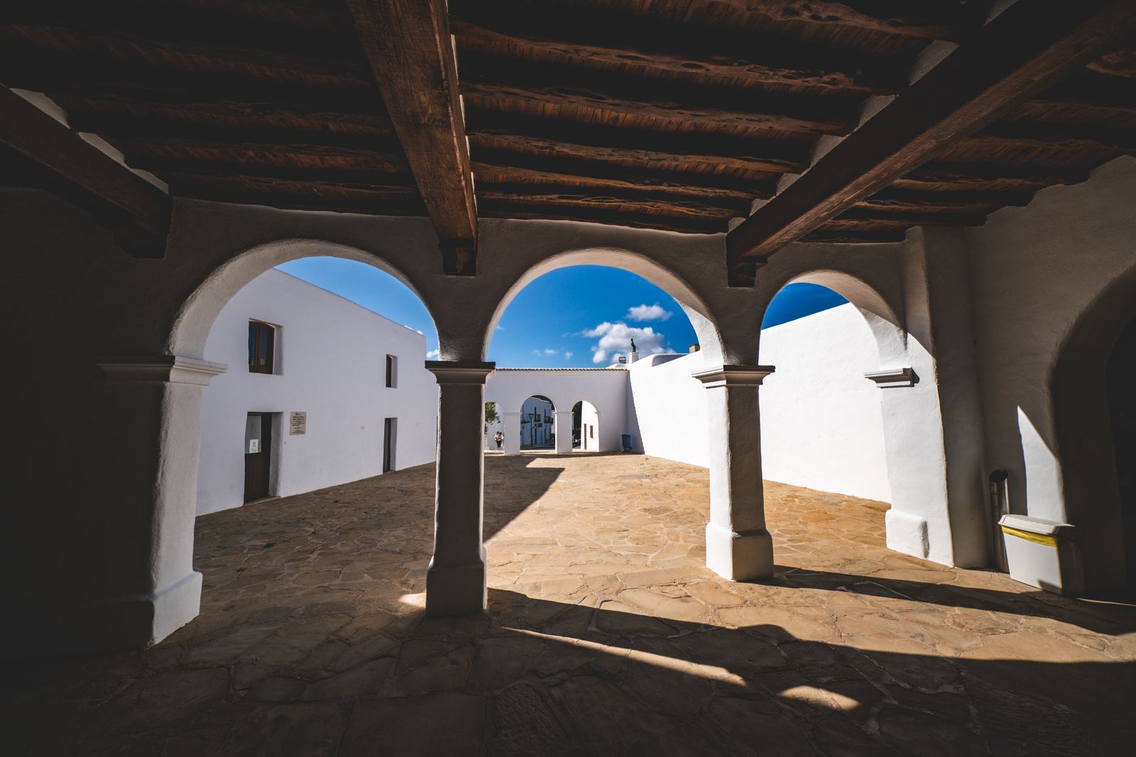 Mediterranean-style courtyard with stone arches, evoking the Italian Forum piazza