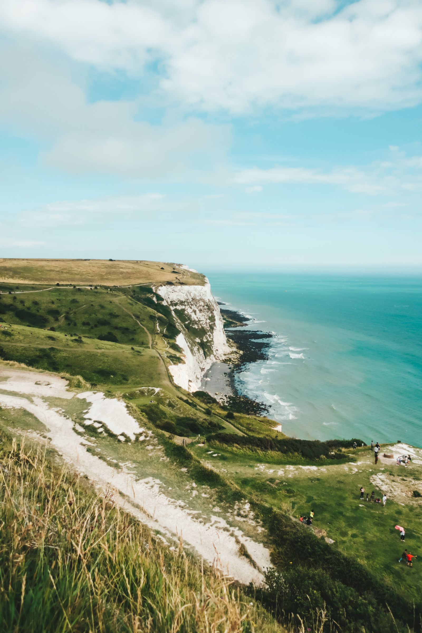 Dramatic coastal cliffs and ocean waves near a South Coast town