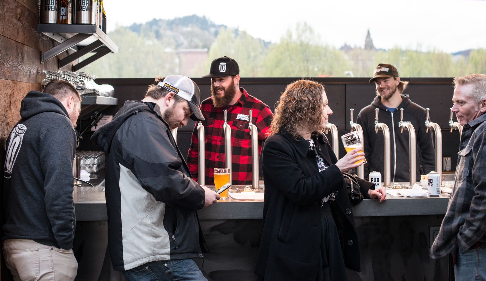 Group of people socialising and drinking beer outdoors