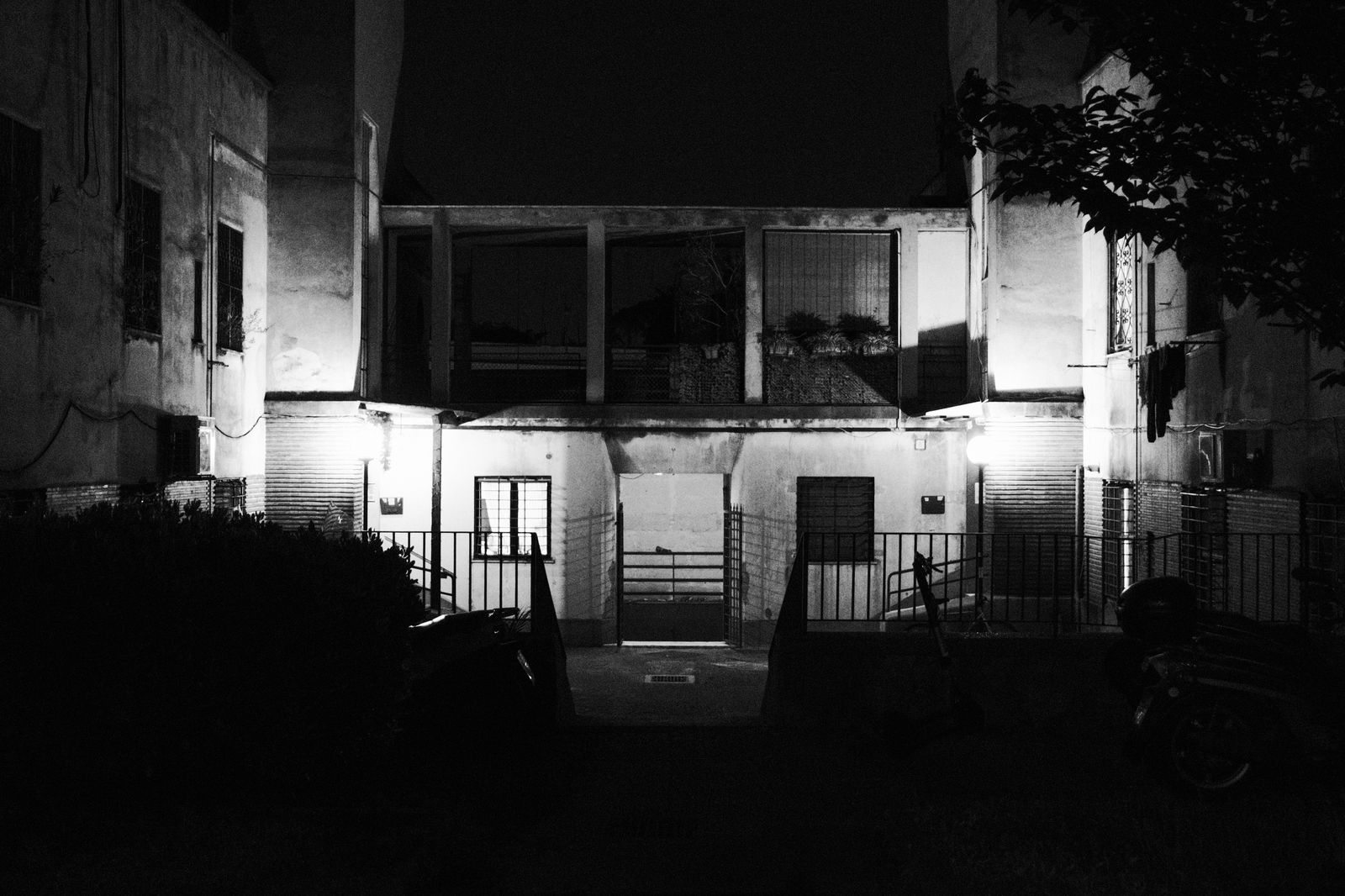 Black and white photo of an old abandoned building illuminated at night