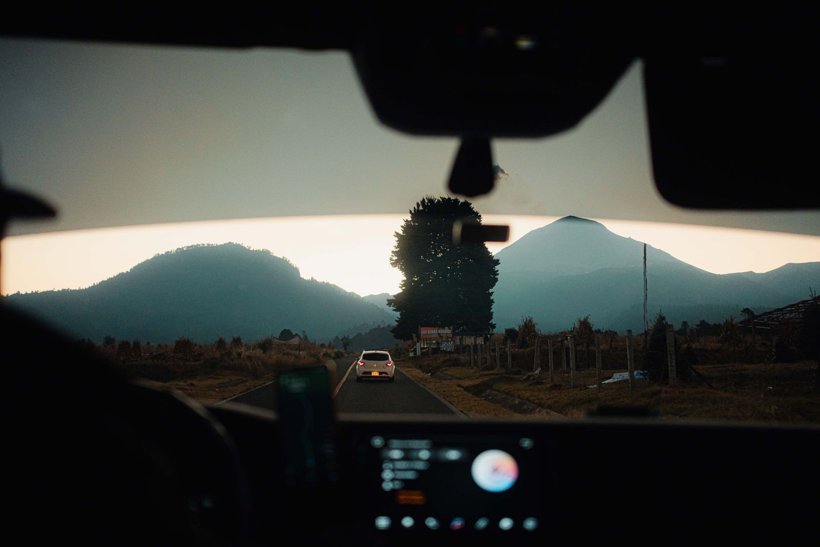 Scenic drive through a mountainous landscape at sunset