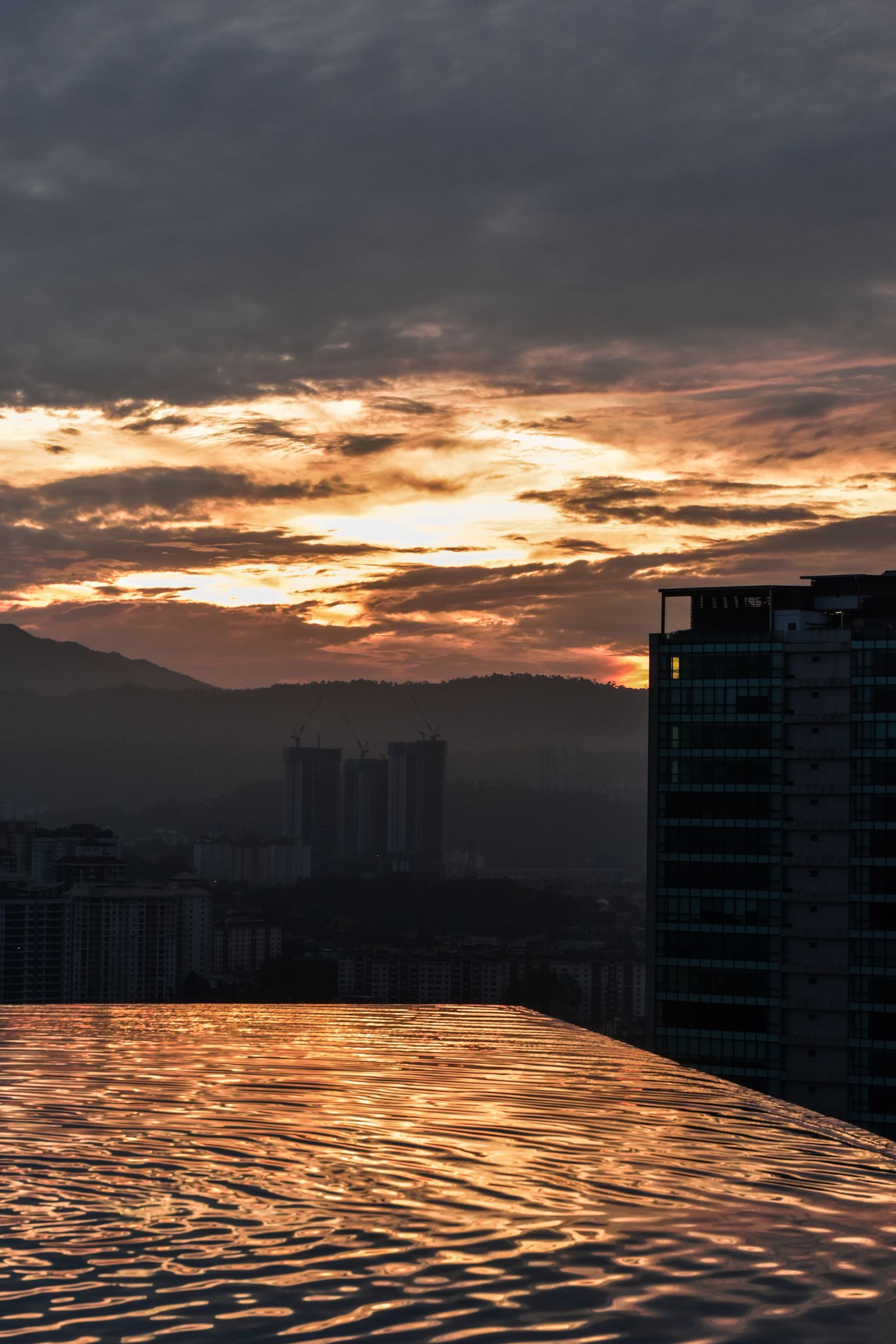 Sunset sky reflected in a rooftop infinity pool