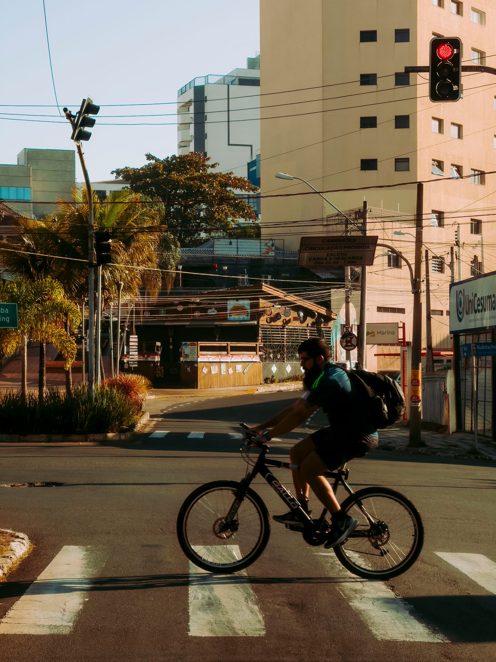 A cyclist riding through a city crosswalk with urban buildings in the background