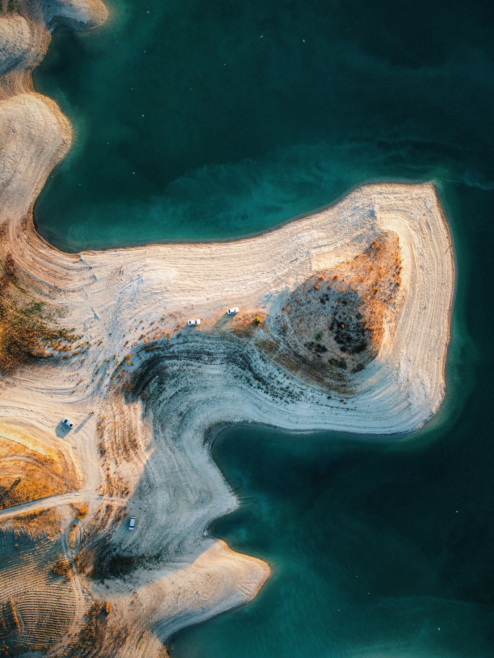 Aerial drone shot of a secluded beach peninsula surrounded by turquoise waters